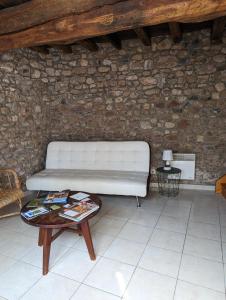 a living room with a white couch and a table at Domaine viticole Philippe Deschamps in Beaujeu