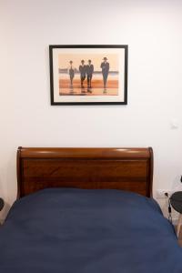 - une chambre dotée d'un lit avec une photo sur le mur dans l'établissement Le Hall-in-one 002 - Spacieux- Tout équipé - Proche commodités et Espace Aréna, à Saint-Chamond