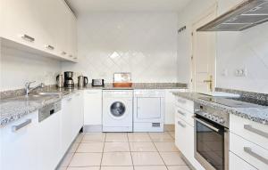 a white kitchen with a washing machine and a sink at Amazing Home In Benahavs With Swimming Pool in Estepona