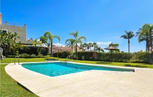 uma piscina num quintal com palmeiras em Amazing Home In Benahavs With Swimming Pool em Estepona