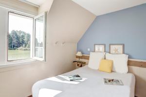 a bedroom with a white bed and a window at Village Pierre & Vacances Belle Dune in Fort-Mahon-Plage