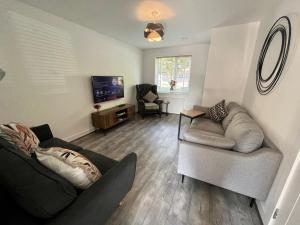 a living room with two couches and a television at Salford Townhouse 3 BR Home in Manchester
