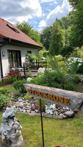 ein Schild vor einem Garten mit einem Haus in der Unterkunft Ferienwohnung Stockrose in Lohme