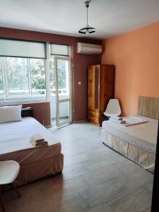 HOTEL PLEVEN في بليفين: سريرين في غرفة بجدران برتقالية ونوافذ