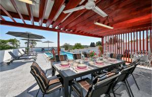 een eettafel met stoelen en een parasol op een patio bij Cozy Home In Sedlarica With Heated Swimming Pool 