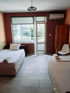 - une chambre avec 2 lits et une grande fenêtre dans l'établissement HOTEL PLEVEN, à Pleven