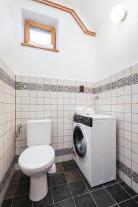 a bathroom with a toilet and a washing machine at Na cestě in Pavlov
