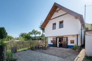 Casa blanca pequeña con patio con bancos en Na cestě en Pavlov