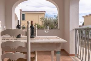 a table on a balcony with a wine glass at Superb Le Residenze del Golfo di Orosei num2191 in Orosei