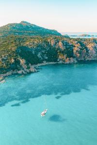 a boat in the water next to an island at Superb Le Residenze del Golfo di Orosei num2191 in Orosei