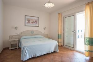 a bedroom with a bed and a sliding glass door at Superb Le Residenze del Golfo di Orosei num2191 in Orosei