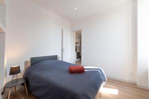 een slaapkamer met een bed met een rood kussen erop bij LE BISTROT 203 - Tout équipé - WIFI & TV in Saint-Chamond