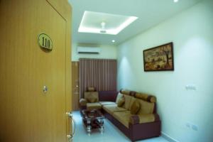 a living room with a couch and a table at The Grand White Palace in Sīrkāzhi