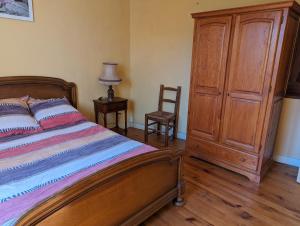 una camera con letto e cassettiera in legno di Domaine viticole Philippe Deschamps a Beaujeu