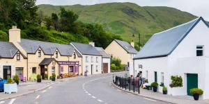 a street in a village with houses and a mountain at TownHouse Leenane in Leenaun