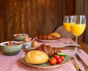 una mesa con un plato de comida y dos vasos de zumo de naranja en B&B Joli met privé wellness, en Wemeldinge