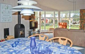 a living room with a table and a couch and a fireplace at Stunning Home In Frvang With 3 Bedrooms, Wifi And Outdoor Swimming Pool in Fårvang