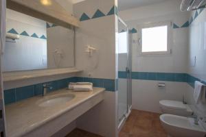 a bathroom with a sink and a toilet and a mirror at Superb Le Residenze del Golfo di Orosei num2192 in Orosei +13 photos