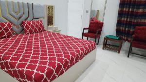 a bedroom with a red bed and two red chairs at Elegant Guest House Karachi in Karachi