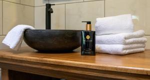 - un lavabo dans la salle de bains avec une bouteille de savon et des serviettes dans l'établissement B&B Joli met privé wellness, à Wemeldinge