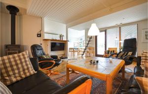 エーベルトフトにあるCozy Home In Ebeltoft With Outdoor Swimming Poolのリビングルーム(革張りの椅子、テーブル付)