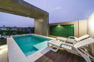a house with a swimming pool and two lounge chairs at 3A - Life Quesada Zona Shopping Mariscal in Asunción
