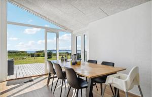 ein Esszimmer mit einem Tisch und Stühlen sowie einem großen Fenster in der Unterkunft Amazing Home In Haarby With House Sea View in Hårby