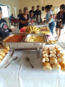 pessoas em torno de um buffet de comida em uma mesa em Hotel Gruta da Serra em Guaramiranga