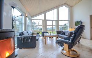 a living room with couches and a fire place at Stunning Home In Ebeltoft With Kitchen in Øksenmølle