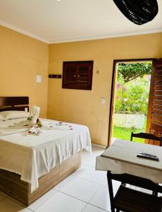 a bedroom with a bed and a table and a window at Hotel Gruta da Serra in Guaramiranga