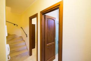 un pasillo con una puerta y escaleras en una casa en Relaxing Le Residenze del Maria Rosaria num2215, en Orosei