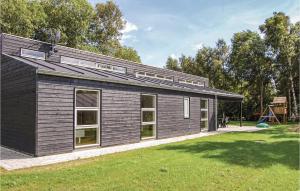 a black building with a playground in a park at Nice Home In Ebeltoft With 3 Bedrooms, Sauna And Wifi in Ebeltoft