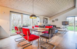 a dining room with a table and red chairs at Beautiful Home In Ebeltoft With Kitchen in Ebeltoft