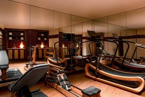 een fitnessruimte met diverse loopbanden en een spiegel bij Château des Fleurs - Hôtel & Spa - Paris Champs-Elysées in Parijs