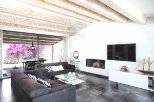 a living room with a couch and a tv at Primera linea Piscina Jacuzzi y Playa Privada in Tossa de Mar