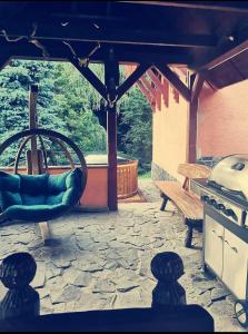 a patio with a swing and a bench and a stove at Chata Hrabovská 
