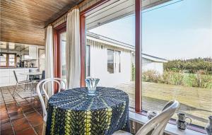 jadalnia ze stołem i dużym oknem w obiekcie Beautiful Home In Ebeltoft With 3 Bedrooms, Sauna And Wifi w mieście Ebeltoft