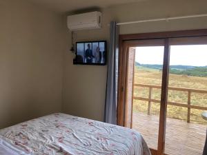 カンバラにあるVale de cambara Iの壁にテレビがありバルコニーがある寝室