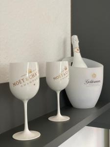 two wine glasses and a bottle on a shelf at Ferienwohnung, schön & modern, Strand/ -Grimmershörnbucht in Cuxhaven