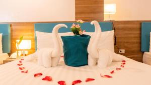 ボラカイにあるBoracay Sea View Hotelのベッドの上にバラで作られた白鳥2羽