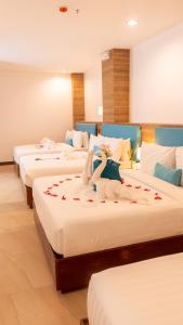 Una habitación de hotel con tres camas con cisnes. en Boracay Sea View Hotel en Boracay