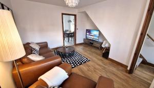 ein Wohnzimmer mit einem Sofa und einem TV in der Unterkunft 3-Bedroom Family Holiday Home in Skegness