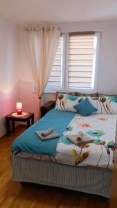 - une chambre avec un lit doté d'une fenêtre et d'une bougie dans l'établissement Felix Apartment Istocno Sarajevo, à Vranješ