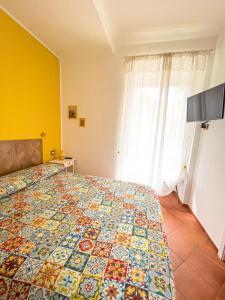 a bedroom with a bed with a colorful quilt at Giallo Napoli in Naples