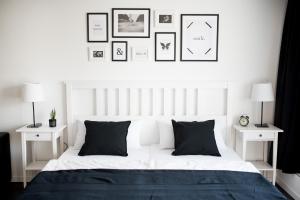 a bedroom with a white bed with black and white pillows at KELLER APARTMENT in Sulz am Neckar