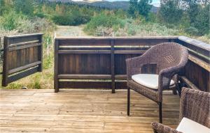 a wicker chair sitting on a wooden deck at Beautiful Home In Nord-torpa With House A Mountain View in Nord Torpa