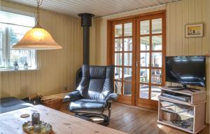 a living room with a chair and a television at 3 Bedroom Nice Home In Sunds in Sunds