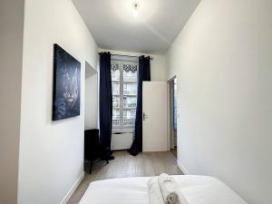 um pequeno quarto com uma cama e uma janela em Cosy appart Lyon Part Dieu Félix 2 em Lyon