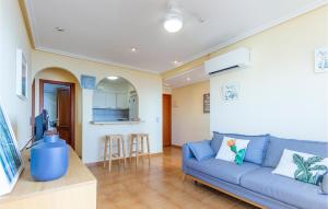 een woonkamer met een blauwe bank en een keuken bij Beautiful Apartment In Santa Pola With Outdoor Swimming Pool in Santa Pola