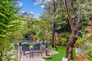 eine Terrasse mit Stühlen und einem Tisch im Garten in der Unterkunft Villa Jaliel 250 m2 - 12 pers. plein coeur de Cannes in Cannes